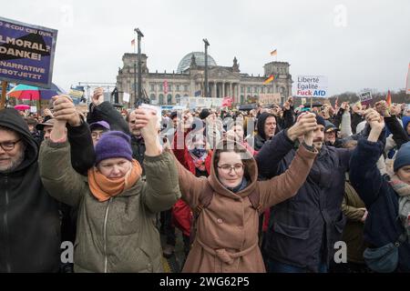 Berlino fu testimone di un monumentale raduno il 3 febbraio 2024, quando circa 300.000 manifestanti formarono un simbolico "firewall" contro l'estremismo di destra davanti al Bundestag sotto la bandiera WeAreTheFirewall. Questa massiccia mobilitazione risponde ai crescenti sentimenti di destra e alle violazioni dei diritti umani all'interno della società e della politica, sostenendo una maggiore tolleranza e una democrazia solida. Il raduno è stato organizzato dalla rete "mano in mano", che ha visto oltre 1.700 organizzazioni firmare una dichiarazione contro l'estremismo di destra, mostrando un fronte unito da un ampio spettro Foto Stock