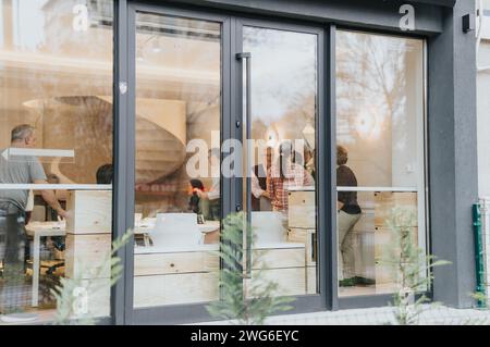 Un gruppo eterogeneo di persone che lavorano insieme in un ufficio moderno, discutendo idee e risolvendo problemi per aumentare la produttività e la redditività. Foto Stock