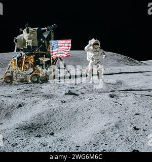 L'astronauta dell'Apollo 16 John W. Young saluta mentre salta accanto alla bandiera americana accanto al modulo lunare Orion con la far Ultraviolet camera/Spectrograph allestita alle sue spalle. Fotografia scattata da Charles M. Duke Jr. Durante la loro prima passeggiata lunare il 21 aprile 1972. Foto Stock