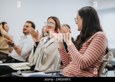 Pubblico coinvolto applaudendo dopo una presentazione di successo in un seminario. Foto Stock