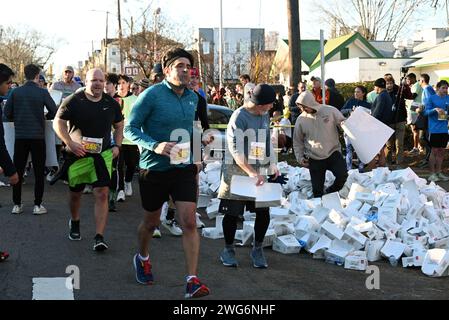 Raleigh, NC, USA, 3 febbraio 2024. Poco più di 4.000 corridori hanno partecipato al 20° Krispy Kreme Challenge annuale, una gara di 5 miglia in cui i corridori si fermano per calare una dozzina di ciambelle smaltate a metà strada. Per la prima volta nel 2004, il Krispy Kreme Challenge è stato utilizzato come raccolta fondi per l'ospedale pediatrico della University of North Carolina, raccogliendo oltre 2 milioni di dollari. Credit D Guest Smith / Alamy Live News Foto Stock