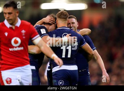 Il scozzese Duhan van der Merwe (centro) festeggia con i compagni di squadra Finn Russell e Jamie Ritchie dopo aver segnato la seconda meta della loro squadra durante la partita del Guinness Six Nations al Principality Stadium di Cardiff. Data immagine: Sabato 3 febbraio 2024. Foto Stock