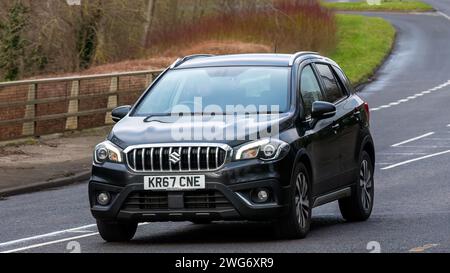 Milton Keynes, Regno Unito - 3 febbraio 2024. 2017 Suzuki SX4 che guida su una strada inglese. Foto Stock