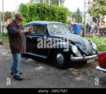 Loenen, Paesi Bassi 8 settembre 2019 Un Maggiolino Volkswagen nero splendidamente restaurato con un turista che fotografa di fronte Foto Stock