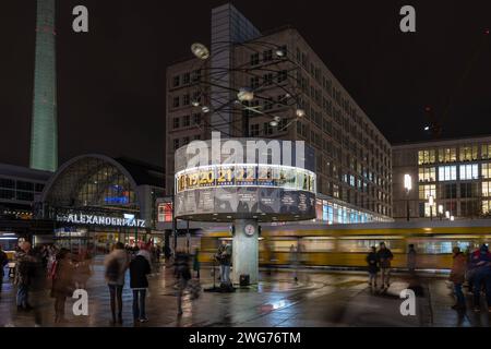 Die Weltzeituhr auf dem Alexanderplatz a Berlino ist ein beliebter Treffpunkt und Buehne fuer Kuenstler. 03.02.2024, Berlino, GER - Die Weltzeituhr auf dem Alexanderplatz. Abendstimmung mit Passanten, Strassenbahn, und Musiker., Berlin Berlin Berlin Deutschland Alexanderplatz, Weltzeituhr *** l'orologio del tempo mondiale su Alexanderplatz a Berlino è un luogo di incontro e palcoscenico popolare per gli artisti 03 02 2024, Berlin, GER The World Time Clock on Alexanderplatz atmosfera serale con passanti, tram, e musicisti , Berlino Berlino Germania Alexanderplatz, World Time Clock Foto Stock