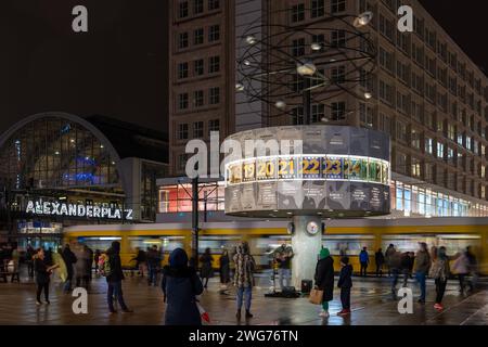 Die Weltzeituhr auf dem Alexanderplatz a Berlino ist ein beliebter Treffpunkt und Buehne fuer Kuenstler. 03.02.2024, Berlino, GER - Die Weltzeituhr auf dem Alexanderplatz. Abendstimmung mit Passanten, Strassenbahn, und Musiker., Berlin Berlin Berlin Deutschland Alexanderplatz, Weltzeituhr *** l'orologio del tempo mondiale su Alexanderplatz a Berlino è un luogo di incontro e palcoscenico popolare per gli artisti 03 02 2024, Berlin, GER The World Time Clock on Alexanderplatz atmosfera serale con passanti, tram, e musicisti , Berlino Berlino Germania Alexanderplatz, World Time Clock Foto Stock