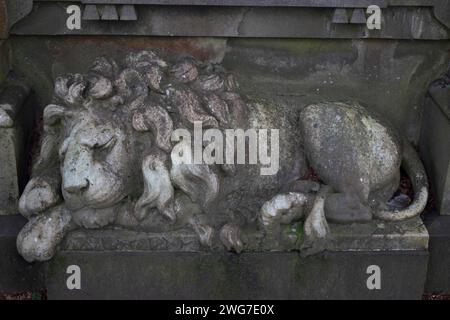 Statua di un leone addormentato su una tomba nel cimitero Dean, un cimitero vittoriano vicino a Dean Village, Edimburgo, Scozia, Regno Unito Foto Stock