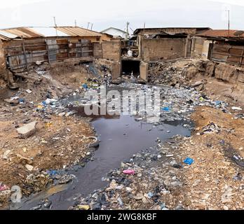 Povertà inquinamento Nina Accra Ghana quartiere Africa. Quartiere di ambiente tossico. Problema di salute. Villaggio inquinato dalla spazzatura, dalla spazzatura e dalle fognature. Foto Stock