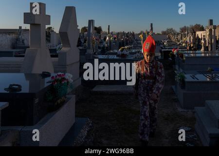 Almonacid De Marquesado, Cuenca, Spagna. 3 febbraio 2024. Un membro della confraternita Endiablada è visto nel cementery della città durante il festival tradizionale "Endiablada" ad Almonacid del Marquesado, Spagna. Ogni anno dal 2 al 3 febbraio, la città di Almonacid del Marquesado, nella Spagna centrale, ospita i vivaci festival "Endiablada" (la Confraternita dei Divili), una tradizione che risale al medioevo o prima in onore della Candelaria e di San Blas. Durante questo vivace evento, i partecipanti di sesso maschile indossano un abbigliamento diabolico, tra cui abiti da tuta vividi e cappelli con guscio rosso. Credito: ZUMA Press, Inc./al Foto Stock