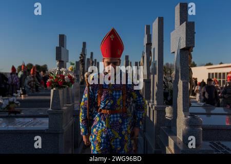 Almonacid De Marquesado, Cuenca, Spagna. 3 febbraio 2024. Un membro della confraternita Endiablada è visto nel cementery della città durante il festival tradizionale "Endiablada" ad Almonacid del Marquesado, Spagna. Ogni anno dal 2 al 3 febbraio, la città di Almonacid del Marquesado, nella Spagna centrale, ospita i vivaci festival "Endiablada" (la Confraternita dei Divili), una tradizione che risale al medioevo o prima in onore della Candelaria e di San Blas. Durante questo vivace evento, i partecipanti di sesso maschile indossano un abbigliamento diabolico, tra cui abiti da tuta vividi e cappelli con guscio rosso. Credito: ZUMA Press, Inc./al Foto Stock