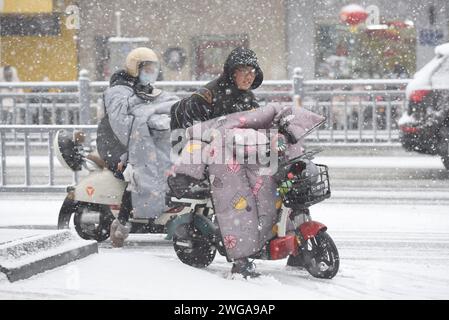 HUAI'AN, CINA - 4 FEBBRAIO 2024 - i cittadini viaggiano lentamente su una strada in una forte nevicata nella città di Huai 'an, provincia di Jiangsu, Cina, 4 febbraio 2024. Foto Stock