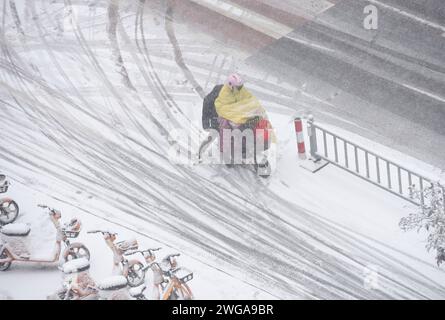 HUAI'AN, CINA - 4 FEBBRAIO 2024 - i cittadini viaggiano lentamente su una strada in una forte nevicata nella città di Huai 'an, provincia di Jiangsu, Cina, 4 febbraio 2024. Foto Stock