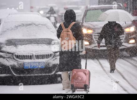 HUAI'AN, CINA - 4 FEBBRAIO 2024 - i cittadini camminano lentamente attraverso una forte nevicata nella città di Huai'an, provincia di Jiangsu, Cina, 4 febbraio 2024. Foto Stock