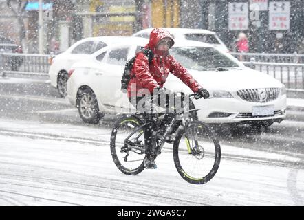 HUAI'AN, CINA - 4 FEBBRAIO 2024 - i cittadini viaggiano lentamente su una strada in una forte nevicata nella città di Huai 'an, provincia di Jiangsu, Cina, 4 febbraio 2024. Foto Stock