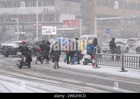 HUAI'AN, CINA - 4 FEBBRAIO 2024 - i cittadini viaggiano lentamente su una strada in una forte nevicata nella città di Huai 'an, provincia di Jiangsu, Cina, 4 febbraio 2024. Foto Stock