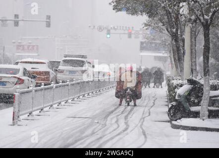 HUAI'AN, CINA - 4 FEBBRAIO 2024 - i cittadini viaggiano lentamente su una strada in una forte nevicata nella città di Huai 'an, provincia di Jiangsu, Cina, 4 febbraio 2024. Foto Stock