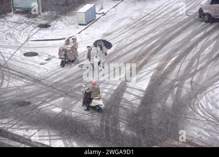 HUAI'AN, CINA - 4 FEBBRAIO 2024 - i cittadini viaggiano lentamente su una strada in una forte nevicata nella città di Huai 'an, provincia di Jiangsu, Cina, 4 febbraio 2024. Foto Stock