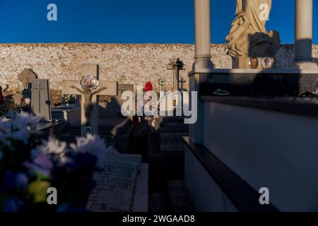 Un membro della confraternita Endiablada vista nel cimitero della città durante il tradizionale festival 'Endiablada'. Ogni anno dal 2 al 3 febbraio, la città di Almonacid del Marquesado, nella Spagna centrale, ospita i vivaci festival 'Endiablada' (la Confraternita dei Diavoli), una tradizione risalente al Medioevo o prima in onore della Candelaria e San Blas. Durante questo vivace evento, i partecipanti di sesso maschile indossano un abbigliamento diabolico, tra cui abiti da tuta vividi e cappelli con guscio rosso. Adornata da campanelle di rame intorno alla vita, la festa si svolge mentre attraversano la strada tortuosa della città Foto Stock