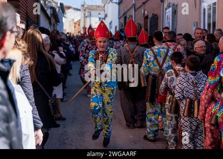 I membri della Fratellanza Endiablada saltano durante il tradizionale festival "Endiablada". Ogni anno dal 2 al 3 febbraio, la città di Almonacid del Marquesado, nella Spagna centrale, ospita i vivaci festival 'Endiablada' (la Confraternita dei Diavoli), una tradizione risalente al Medioevo o prima in onore della Candelaria e San Blas. Durante questo vivace evento, i partecipanti di sesso maschile indossano un abbigliamento diabolico, tra cui abiti da tuta vividi e cappelli con guscio rosso. Adornata da campanelle di rame intorno alla vita, la festa si svolge mentre attraversano le strade serpeggianti della città, impegnandosi in danc Foto Stock