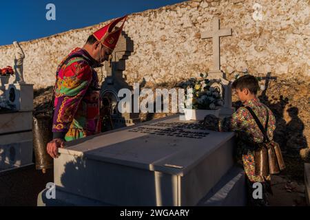 I membri della Fratellanza Endiablada pregano per i compagni defunti e i parenti durante il festival tradizionale "Endiablada". Ogni anno dal 2 al 3 febbraio, la città di Almonacid del Marquesado, nella Spagna centrale, ospita i vivaci festival 'Endiablada' (la Confraternita dei Diavoli), una tradizione risalente al Medioevo o prima in onore della Candelaria e San Blas. Durante questo vivace evento, i partecipanti di sesso maschile indossano un abbigliamento diabolico, tra cui abiti da tuta vividi e cappelli con guscio rosso. Adornata da campanelli di rame intorno alla vita, la festa si svolge mentre attraversano Foto Stock