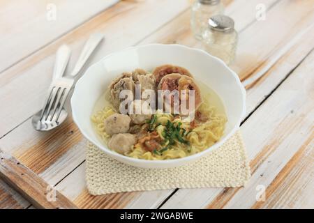 Bakso o Baso, zuppa indonesiana di polpette, servita con spaghetti gialli Foto Stock