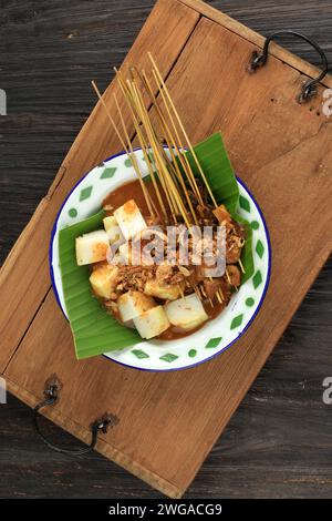 Sate Padang o Satay Padang, Spicy Beef Satay di Padang, West Sumatra. Servito con salsa al curry piccante e Ketupat Foto Stock