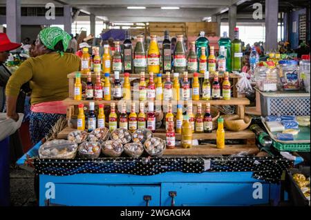 Una bancarella di venditori con file di colorate salse calde locali e spezie al Castries Central Market, Castries, St. Lucia, gennaio 2024. Foto Stock