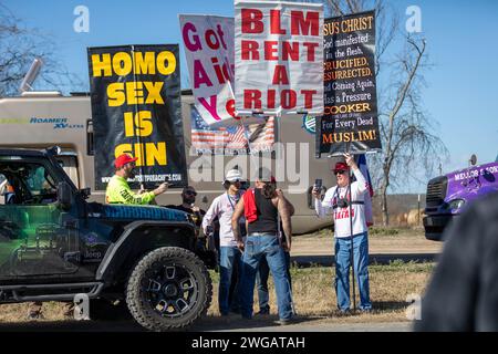 QUEMADO, TEXAS - 3 FEBBRAIO: I membri della Westboro Baptist Church tengono cartelli e discutono con i partecipanti al raduno di convogli "Take Our Border Back" al Cornerstone Children's Ranch il 3 febbraio 2024 a Quemado, Texas. Il convoglio di "patrioti", che affermano che i "globalisti" stanno cospirando per mantenere aperti i confini degli Stati Uniti per distruggere il paese, si dirigono verso il confine tra Stati Uniti e Messico, mentre la situazione di stallo tra Texas e governo federale si intensifica. (Foto di Michael Nigro/Sipa USA) credito: SIPA USA/Alamy Live News Foto Stock