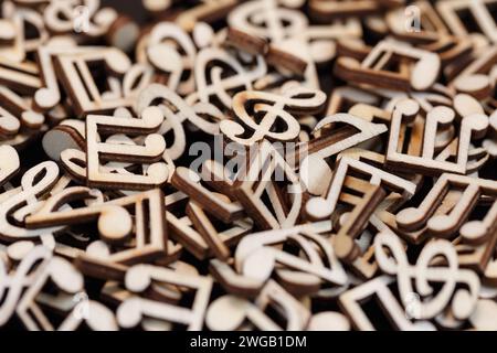 Note musicali fatte di legno accumulate in un mucchio. Macrofotografia a bassa profondità di campo Foto Stock