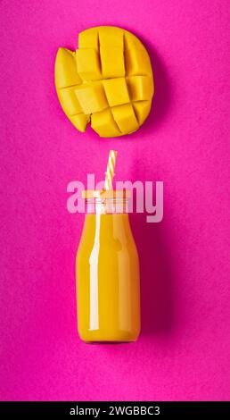 succo di mango imbottigliato e porzione di mango fresco in pezzi isolati dallo sfondo. Copia spazio Foto Stock
