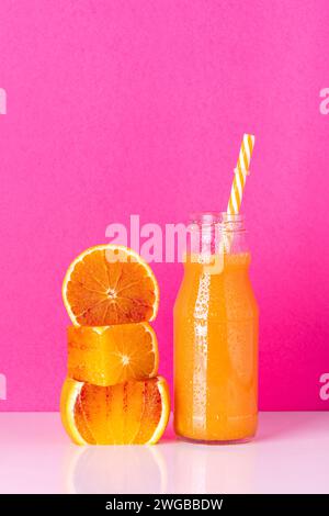 succo in bottiglia e fette di arance fresche isolate dallo sfondo. Foto Stock