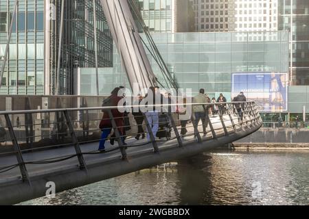 Persone che camminano attraverso il ponte pedonale di South Quay dall'Isola dei cani verso Canary Wharf Buildings, London docklands area, Inghilterra, Regno Unito Foto Stock