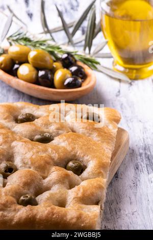 In primo piano gustosa focaccia genovese con olive, in crosta e olive sullo sfondo. Foto Stock