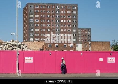 Un uomo passa davanti ai blocchi di torre in attesa di essere demolito nella tenuta Gascoigne, Barking, East London. Riqualificazione edilizia abitativa, 2023. Foto Stock