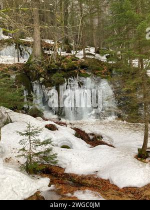 Alcune montagne innevate e ruscelli ricoperti da neve scintillante e ghiaccio Foto Stock