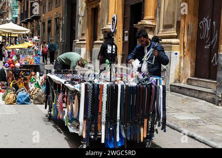 Palermo, Italia - 13 maggio 2023: Venditore al suo stand che vende borse, cinture, borse, vestiti e occhiali da sole in una via dello shopping via Maqueda a Palermo, si Foto Stock