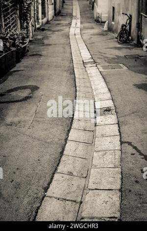 Canale poco profondo per abbattere l'acqua piovana in una strada a Montpellier, Francia Foto Stock