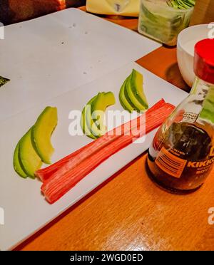 Preparatevi per condire sushi, avocado e bastoncini di granchio con salsa di soia Foto Stock