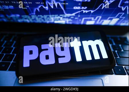 In questa foto, un logo PayTM viene visualizzato su uno smartphone con le percentuali del mercato azionario sullo sfondo. Foto Stock