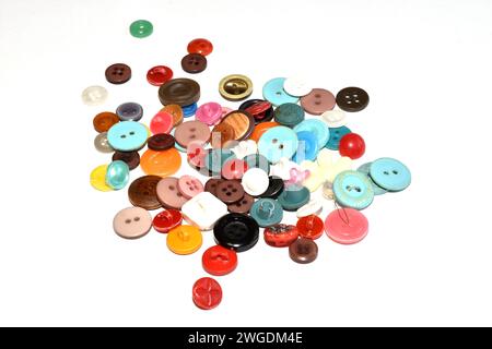 Bottoni colorati di diverse dimensioni si trovano in una pila su sfondo bianco. Foto Stock