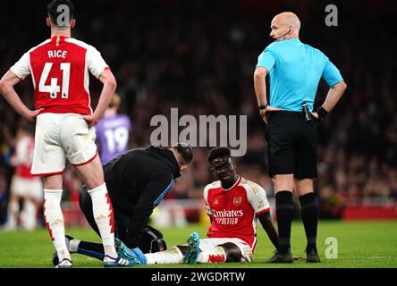 Il Bukayo Saka (centro) dell'Arsenal riceve un trattamento prima di essere sostituito durante la partita di Premier League all'Emirates Stadium di Londra. Data immagine: Domenica 4 febbraio 2024. Foto Stock