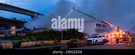 RICHMOND, BC, CANADA - 27 LUGLIO 2023: Vigili del fuoco e camion dei vigili del fuoco di Richmond che combattono un incendio infuriante, servizi di emergenza, soccorritori, fumo, acqua Foto Stock