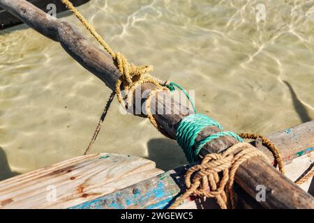 Semplice corda naturale legata intorno alla parte in legno della barca da pesca, dettaglio closeup Foto Stock