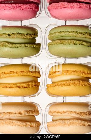 Macaron in scatola di plastica su sfondo isolato, vista dall'alto Foto Stock