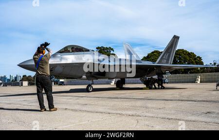 Un comandante dell'equipaggio della U.S. Air Force schierato con il 525th Expeditionary Fighter Generation Squadron, 3rd Air Expeditionary Wing, Joint base Elmendorf-Richardson, Alaska, Marshals an F-22 Raptor durante l'esercitazione Bamboo Eagle 24-1 presso la Naval Air Station North Island, California, 28 gennaio 2024. La NAS North Island servì come uno dei raggi all'interno del concetto di operazioni hub-and-spoke durante l'esercitazione Bamboo Eagle 24-1, con l'hub e l'elemento di forza di comando e controllo situato a Nellis Air Force base, Nevada. Durante BE 24-1, i combattenti hanno implementato la generazione di energia da combattimento a tutti i domini da ba disaggregata Foto Stock