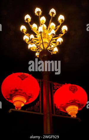 I lampioni rossi Crimson illuminano la Beijing Middle Road nella città di Lhasa, emettendo sfere di luce diffrante. Foto Stock