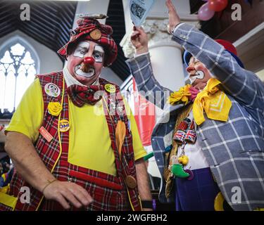Londra, Regno Unito. 4 febbraio 2024. I clown si riuniscono nei loro costumi alla Haggerston All Saints Church per il servizio Grimaldi, ora al suo 78° anno. Il servizio e l'evento circostante si svolgono ogni anno in onore del famoso intrattenitore dell'era Regency Joseph Grimaldi, e celebrano la vita dei clown della comunità che potrebbero essere morti di recente. Crediti: Imageplotter/Alamy Live News Foto Stock