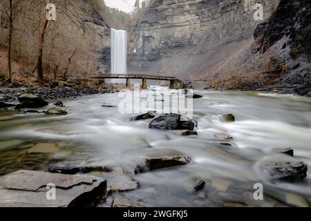 Foto invernale a lunga esposizione delle cascate Taughannock e del ponte al Taughannock Falls State Park vicino a Ithaca NY. (02-03-2024) Foto Stock