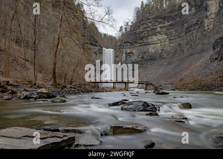 Foto invernale a lunga esposizione delle cascate Taughannock e del ponte al Taughannock Falls State Park vicino a Ithaca NY. (02-03-2024) Foto Stock