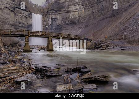 Foto invernale a lunga esposizione delle cascate Taughannock e del ponte al Taughannock Falls State Park vicino a Ithaca NY. (02-03-2024) Foto Stock